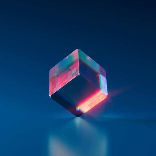 A transparent cube on one edge reflecting the blue and red colors in a dark blue background.